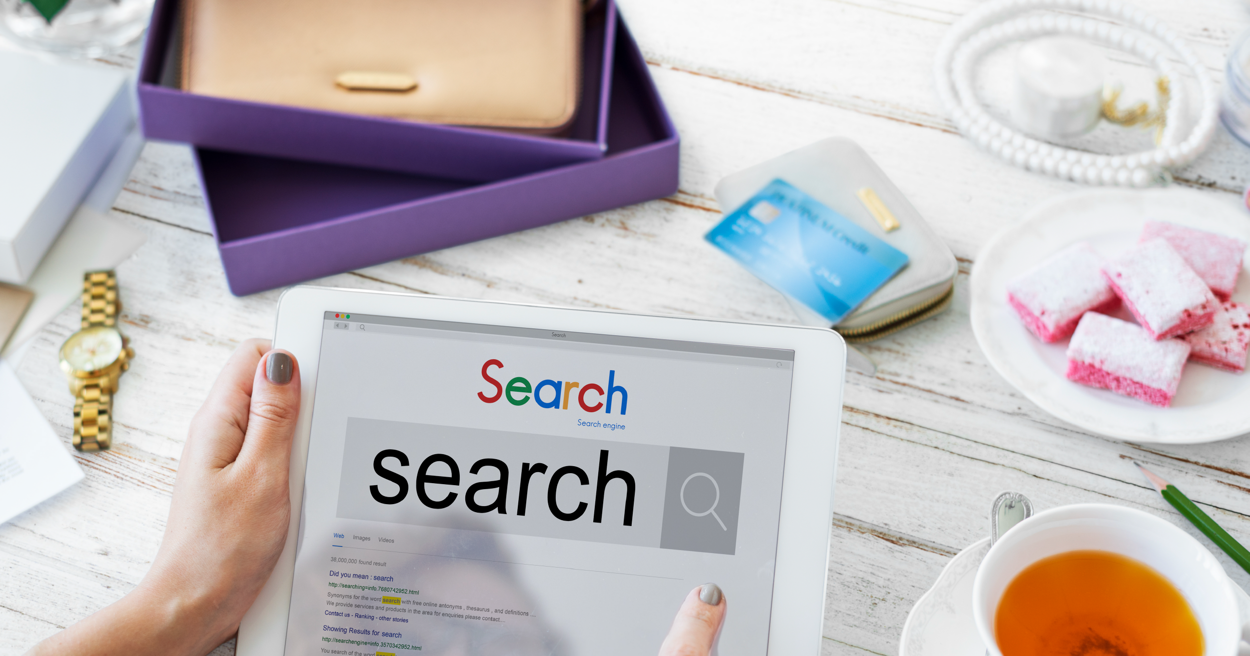 A lady holding a tablet and searching on internet