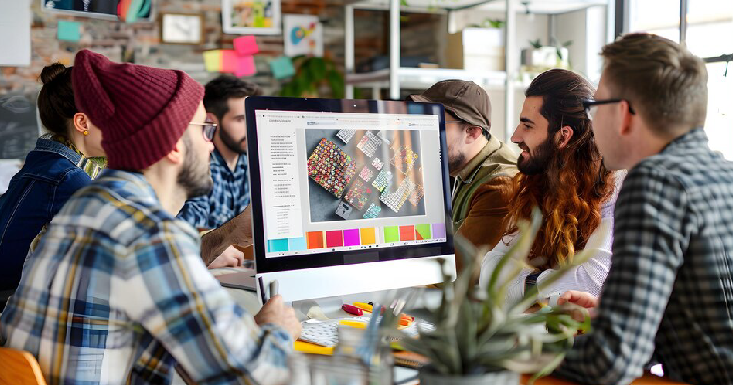 group of graphic designers discussing something on a monitor